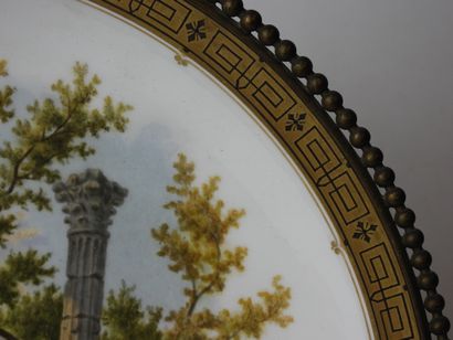 null SEVRES. Plat circulaire en porcelaine au décor néo-classique, frise dorée sur...