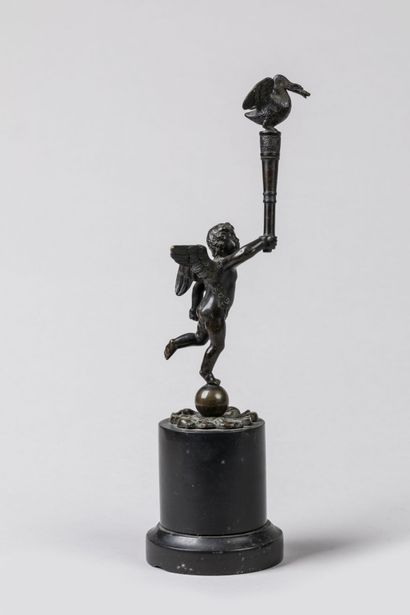 null STATUETTE en bronze patiné représentant un Angelot portant une torche surmontée...