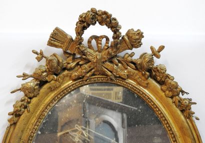 null Miroir ovale de style Louis XVI et bois et stuc doré agrémenté en sa partie...