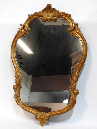 null A Louis XV style wood and gilded stucco mirror with rocaille decoration.
H.:...