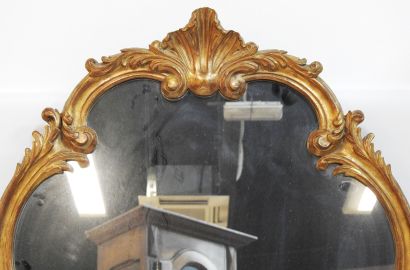 null A Louis XV style wood and gilded stucco mirror with rocaille decoration.
H.:...