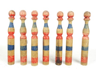 null SEVEN antique painted wood bowling pins with blue and red stripes. H : 19 cm....
