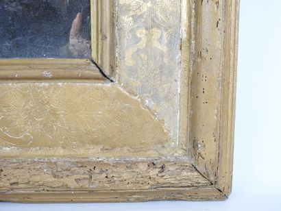 null Gilded stuccoed wood mirror with incised floral decoration. Tain au mercure....