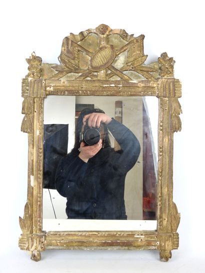 null Gilded stuccoed wood MIRROR, the pediment decorated with flags and laurel leaves....