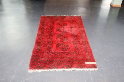 null Petit tapis turkmène de style Boukhara à motifs de göls sur champ rouge foncé,...