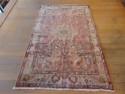 null Persian carpet with central medallion and stylized motifs on old pink field,...