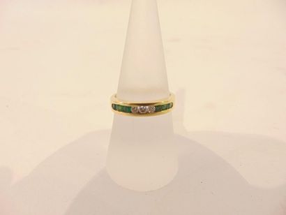 null Ring in 18 karat yellow gold set with a line of emeralds and brilliants, punched,...