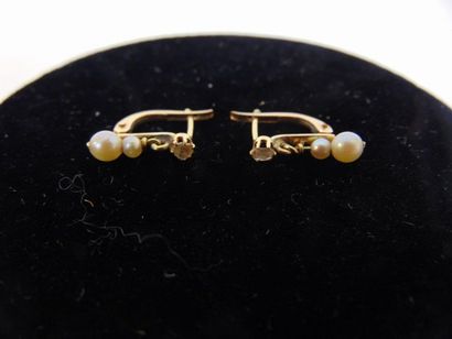 null Pair of 18 karat yellow gold earrings set with a brilliant and pearls, with...