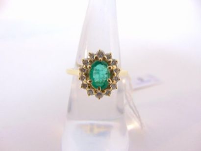 null Ring in 18 karat yellow gold set with an oval emerald in a circle of diamonds,...