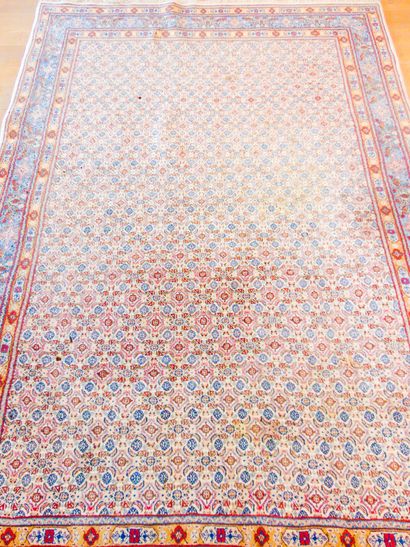 null A large Persian carpet in the Moud style with a stylised pattern on an ivory...