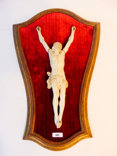 null A 19th-century wall crucifix, carved ivory mounted on a velvet background in...