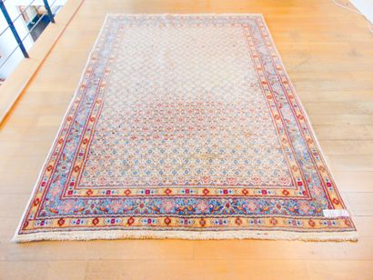 null A large Persian carpet in the Moud style with a stylised pattern on an ivory...