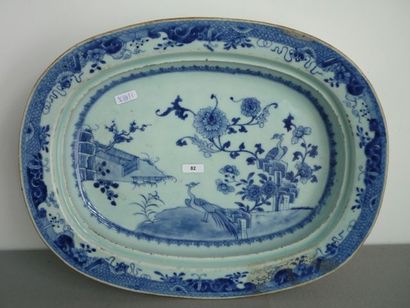 CHINE, XIXe Plat incurvé en porcelaine blanche, décor floral et d'oiseaux du paradis...