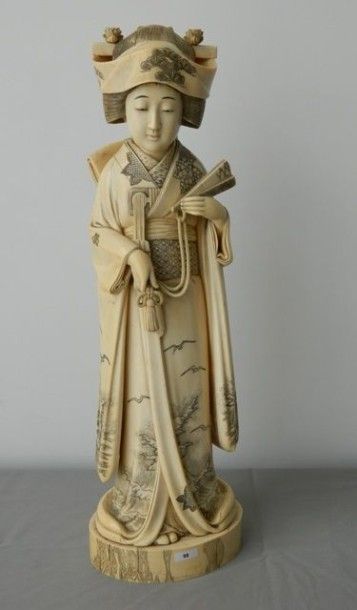 CHINE, XIXe Kwanine en ivoire sculpté et gravé, tenant un éventail dans les mains,...