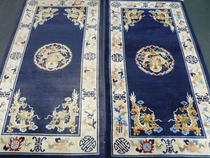 CHINE Paire de tapis ornés de dragons sur fond bleu foncé, XXe, 197x92 cm.