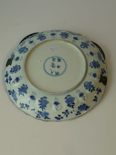 CHINE Plat rond incurvé en porcelaine à décor animé autour de rochers en camïeu bleu,...