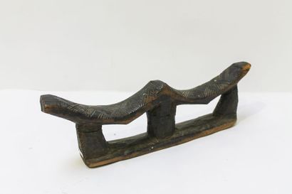 ART TRIBAL Repose-tête double, XXe, bois sculpté à patine foncée, l. 46 cm.