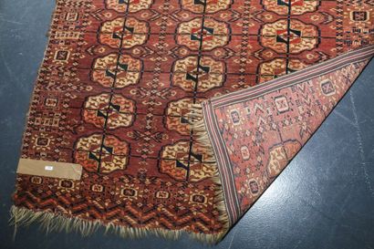 null Petit tapis turkmène de style Boukhara à semis de göls sur champ brun-rouge,...