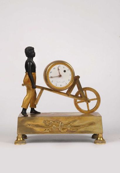 null Petite horloge de cheminée en bronze doré et patiné en forme d’un nègre poussant...