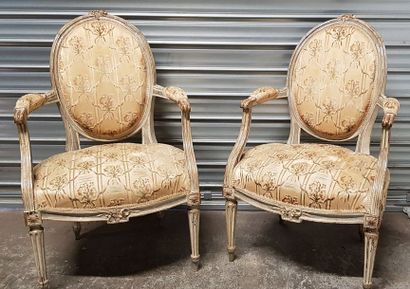 null Une paire de fauteuils à dossiers médaillon en bois mouluré et sculpté de fleurettes...