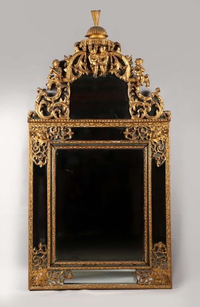 null "Miroir à parecloses en bois sculpté et doré surmonté d’un fronton à décor de...