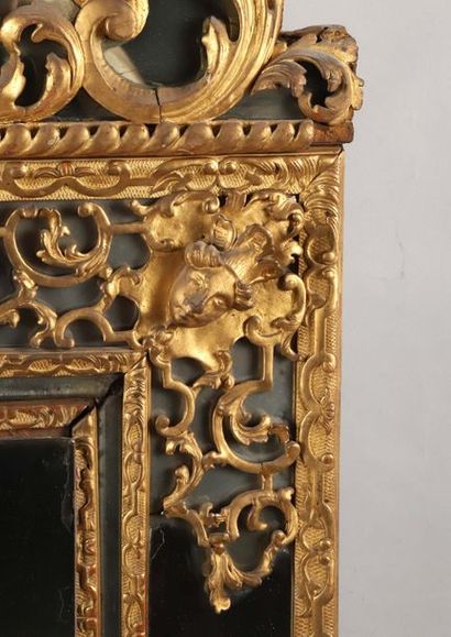 null "Miroir à parecloses en bois sculpté et doré surmonté d’un fronton à décor de...