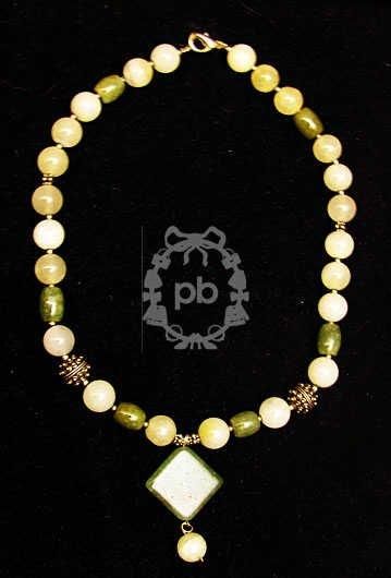 ANONYME COLLIER composé de perles en verre translucide blanc et imitant le jade retenant...