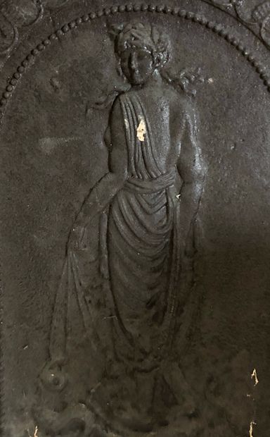 null Une plaque de cheminée en fonte à décor d'une femme drapée à l'Antique foulant...