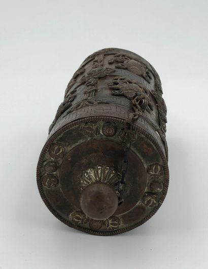 null Cylindrical copper case, decorated in relief with eight precious objects in...