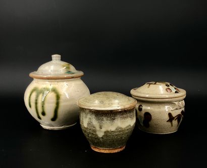 null Set of three enameled stoneware covered pots, one brown with cream-colored drips,...