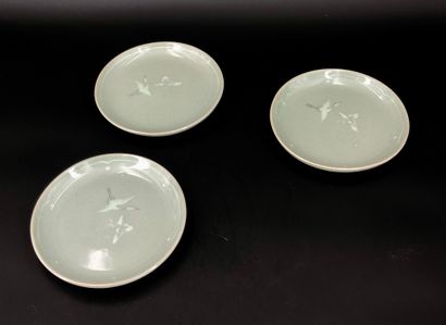 null Three celadon glazed stoneware mukozuke plates, decorated with a crane inlaid...