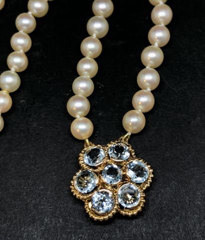null Collier de perles fantaisie retenant en pendentif une fleur en or jaune 18K...