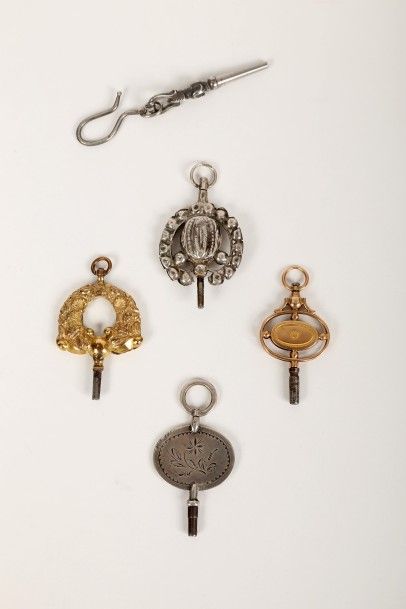 null Cinq clés de montre de formes variées dont une en or et trois en argent.
