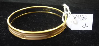 HERMES 
Bracelet jonc en métal doré émaillé à décor de cordages. 
Signé Hermès.