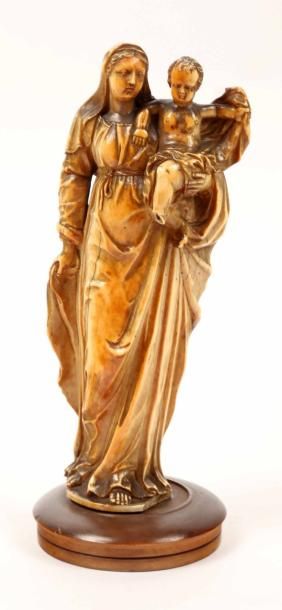 null Statuette finement sculptée en ivoire patiné. Vierge debout portant l'Enfant...