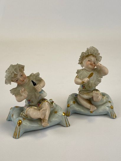  Deux sujets en porcelaine à l'effigie de "Piano Babies" en biscuit et robe dentelle...
