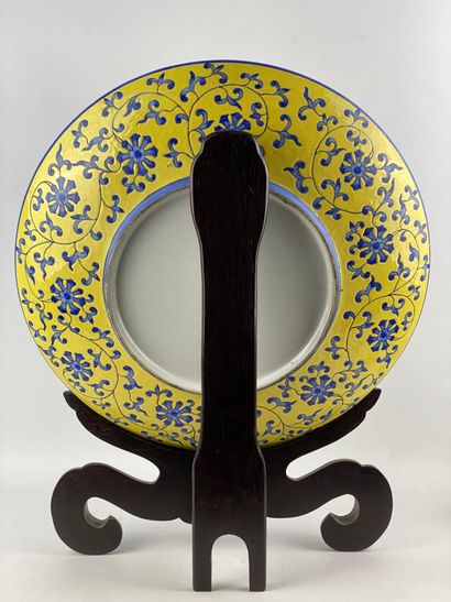  Important plat circulaire en céramique à décor floral bleu sur fond jaune Marque...