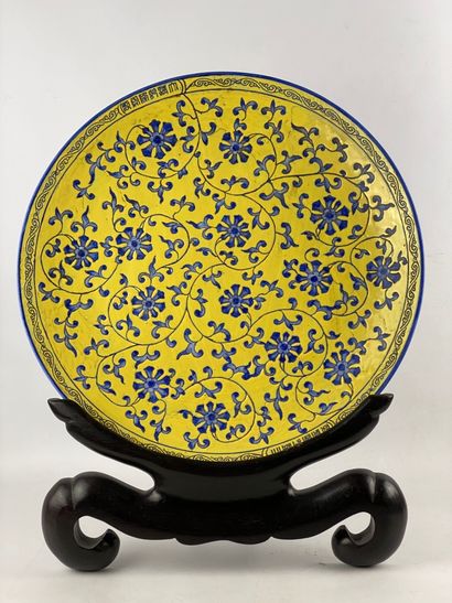  Important plat circulaire en céramique à décor floral bleu sur fond jaune Marque...