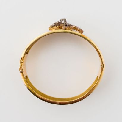  Yellow gold (750) and silver (min. 800) rigid opening bangle bracelet centered on...