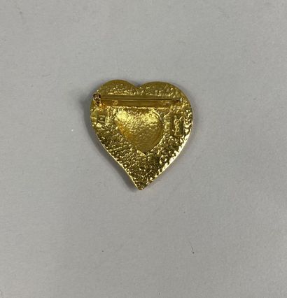  Yves SAINT LAURENT 
Broche en métal doré figurant un coeur, inscription "Yves Saint...