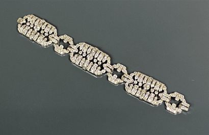  Bracelet articulé en or gris (750) et platine (850) formé de trois plaques rectangulaires...