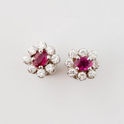  Pair of white gold (750) flower-shaped stud earrings centered on an oval faceted...