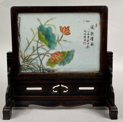  CHINE 
Ecran en porcelaine émaillée à décor de fleurs de lotus. 
Socle en bois sculpté...