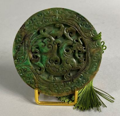  CHINE, XXe siècle 
Disque en pierre dure teintée imitant le jade scupté de rinceaux...