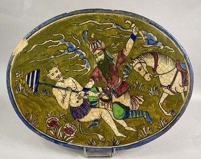  IRAN, XXe 
Plaque ovale en céramique émaillée polychrome à décor de cavalier chassant...
