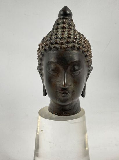  THAILANDE 
Tête de bouddha en bronze. Le visage serein, il est représenté les yeux...