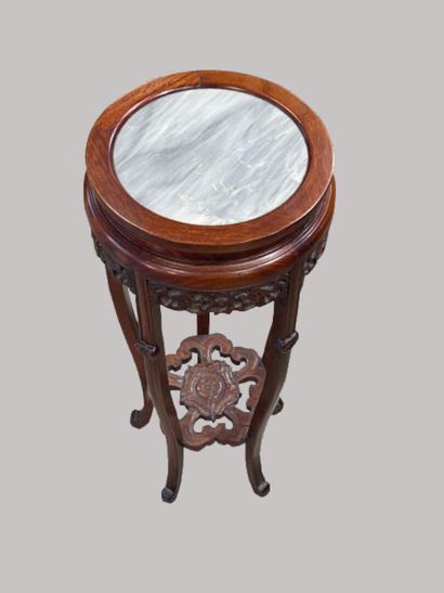  CHINA 
Round quadripod pedestal table in carved wood. Inlaid grey marble top. The...