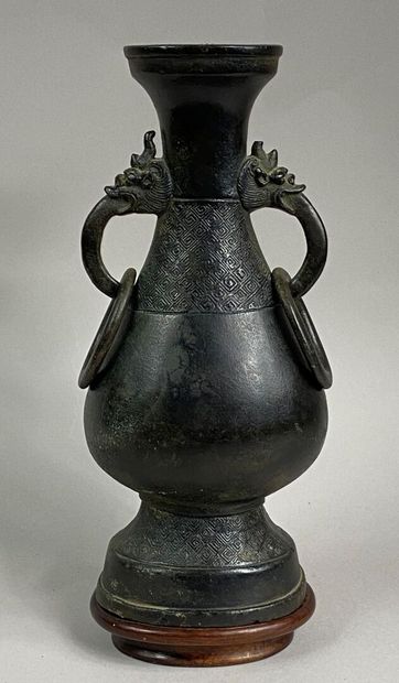  CHINE 
Vase balustre en bronze à patine combre, les deux anses à tête de dragons...