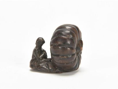 null JAPON, netsuke en bois sculpté figurant une citrouille avec un moine assis en...