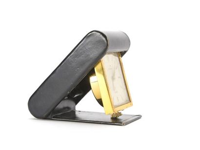 null Hermès - Jaeger-Lecoultre 
Pendulette de voyage en métal cuivré et box en cuir...